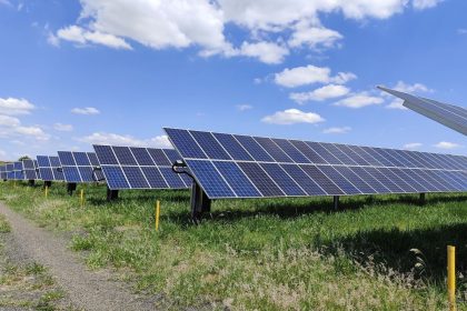 Fileiras de painéis solares em um campo sob céu azul, em Uberlândia, Minas Gerais.