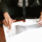Empresário analisa documentos financeiros e números sobre a mesa em um ambiente de escritório.